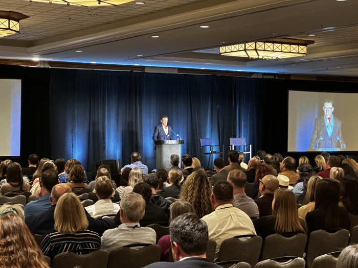 Speaker at a podium in front of an audience