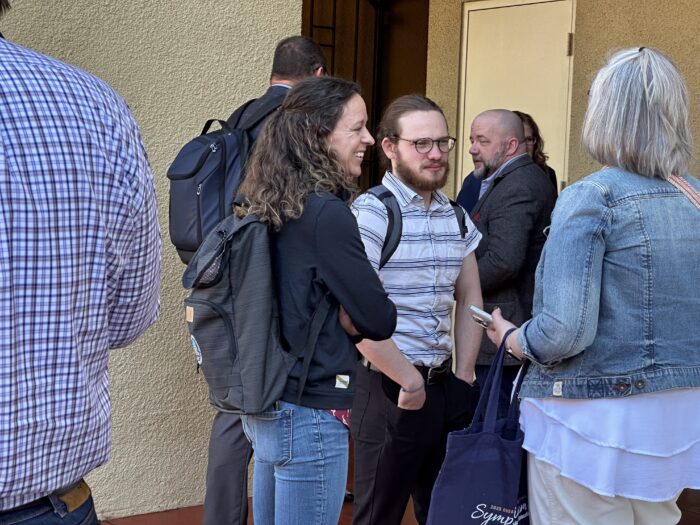 Symposiasts talking in hallway