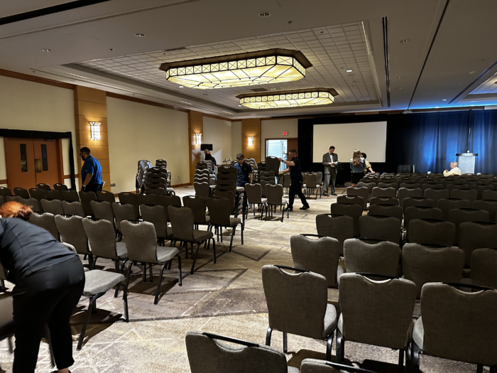 Chairs being stacked a a ballroom