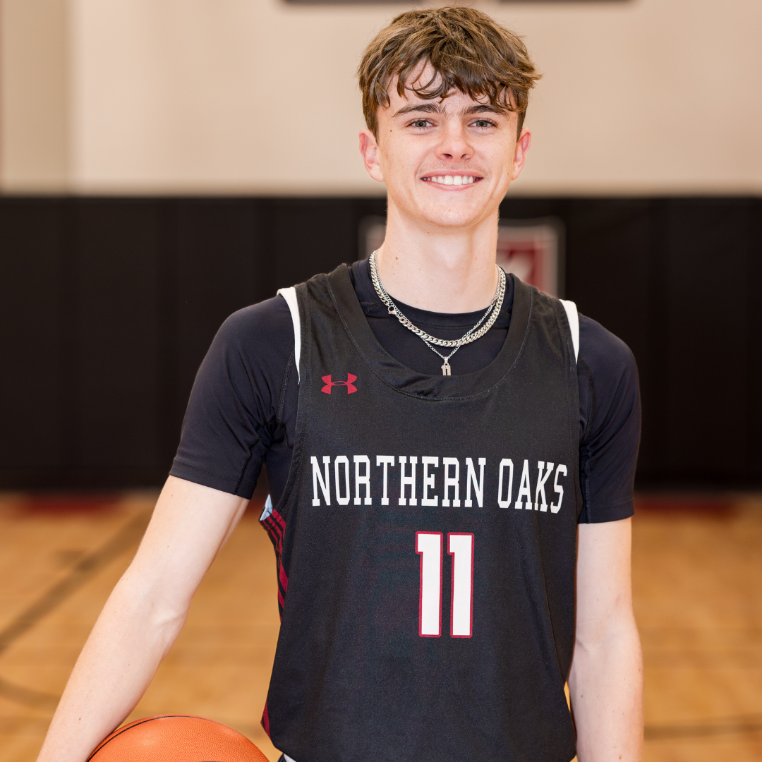 Student Athlete in basketball uniform, holding a basketball on a court