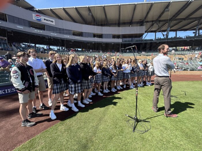 Choir director with choir on a baseball field