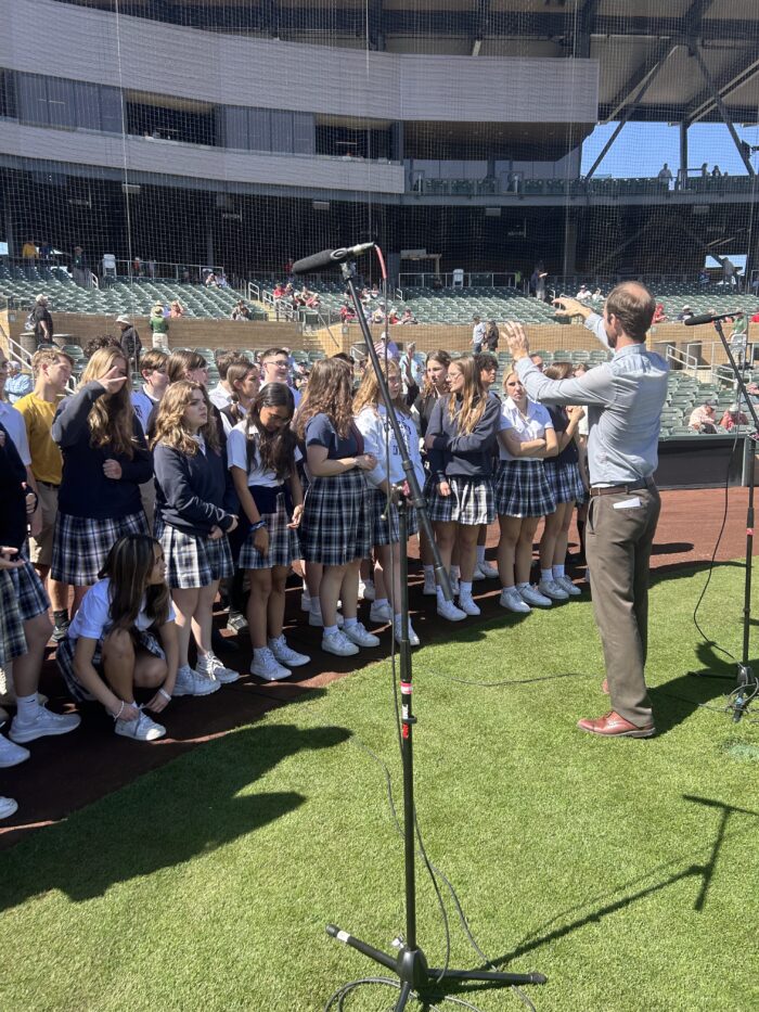 Choir director with choir on a baseball field