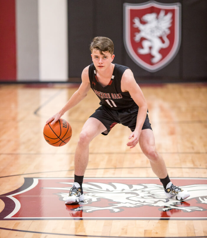 Student basketball player dribbling ball on a court